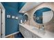 Bright bathroom featuring double sinks, circular mirrors, and stylish modern accents at 5020 W Quarles Dr, Littleton, CO 80128