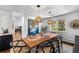 Bright dining room with a wooden table, modern light fixtures, and a view of the backyard at 5020 W Quarles Dr, Littleton, CO 80128