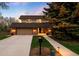 Charming two-story home featuring a well-manicured front yard and stone accents at dusk at 5020 W Quarles Dr, Littleton, CO 80128