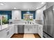 Bright kitchen featuring white cabinets, stainless steel appliances, and marble countertops at 5020 W Quarles Dr, Littleton, CO 80128