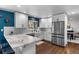 Well-lit kitchen with stainless steel refrigerator, white cabinets and marble countertops at 5020 W Quarles Dr, Littleton, CO 80128
