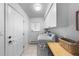 Functional laundry room with white cabinets and side-by-side washer and dryer at 5020 W Quarles Dr, Littleton, CO 80128