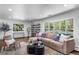 Bright and airy living room featuring a cozy sectional sofa, modern shelving, and large windows at 5020 W Quarles Dr, Littleton, CO 80128