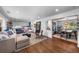 Open-concept living room with hardwood floors, stylish furnishings, and a view into the dining area at 5020 W Quarles Dr, Littleton, CO 80128