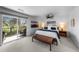 Bright main bedroom with a private balcony and serene backyard views at 5020 W Quarles Dr, Littleton, CO 80128