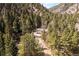 Stunning aerial view of a mountain home nestled among lush trees and surrounded by scenic mountain views at 993 Fall River Rd, Idaho Springs, CO 80452