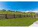 Spacious backyard with artificial turf, a dark wood fence, and neighborhood views in the distance at 3898 Descent St, Castle Rock, CO 80108
