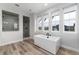 Bright bathroom features a modern soaking tub, standalone shower, and three large windows for ample natural light at 3898 Descent St, Castle Rock, CO 80108