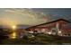 Modern clubhouse with sleek architecture, ample parking, and scenic landscaping at sunset at 3898 Descent St, Castle Rock, CO 80108