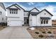 Beautiful two-story home with white siding, black trim, a two-car garage, and rock landscaping at 3898 Descent St, Castle Rock, CO 80108