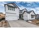 Stunning two-story white home featuring a three-car garage and modern architectural details at 3898 Descent St, Castle Rock, CO 80108