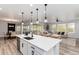 Bright, open-concept kitchen with white cabinets, a large island, and stainless steel appliances at 3898 Descent St, Castle Rock, CO 80108