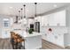 Modern kitchen with white cabinets, quartz countertops, and a large island with bar seating at 3898 Descent St, Castle Rock, CO 80108