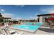 Community pool with lounge chairs, tables, umbrellas, and a modern clubhouse at 3898 Descent St, Castle Rock, CO 80108