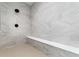 The newly remodeled shower features sleek marble tiling, a bench, and modern matte black fixtures at 3898 Descent St, Castle Rock, CO 80108