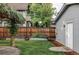 Secluded backyard view with a wooden fence, detached garage, green lawn, and landscaped garden at 424 N Clarkson St, Denver, CO 80218