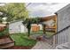 Charming backyard featuring a pergola-covered patio, lush lawn, garden beds, and a detached garage at 424 N Clarkson St, Denver, CO 80218