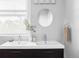 Modern bathroom with a double sink vanity, round mirror, and bright natural light at 424 N Clarkson St, Denver, CO 80218