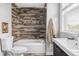 Stylish bathroom with wood-like tile, a shower-tub, decorative accents, and bright natural light at 424 N Clarkson St, Denver, CO 80218