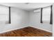 Minimalist bedroom features hardwood floors, a modern air conditioning unit, and dual windows with blinds at 424 N Clarkson St, Denver, CO 80218