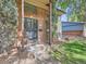 Inviting covered front entrance with security door and landscaped front yard featuring mature trees at 6160 Taft Ct, Arvada, CO 80004