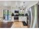 Bright kitchen boasts stainless steel appliances, white cabinets, modern backsplash, and hardwood floors at 6160 Taft Ct, Arvada, CO 80004