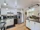 Bright kitchen with white cabinetry, stainless steel appliances, and a cozy island featuring a wooden countertop at 6160 Taft Ct, Arvada, CO 80004