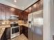 Chef's kitchen featuring stainless steel appliances, custom cabinets and decorative tile backsplash at 2216 S Nile Ct, Aurora, CO 80014