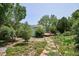 Enjoy this backyard featuring stone path, mature trees, lush landscaping, and back deck at 800 Park View Pl, Castle Rock, CO 80104