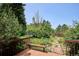 Spacious wood deck overlooking a private backyard with mature trees, shrubs and stone pathway at 800 Park View Pl, Castle Rock, CO 80104