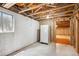Unfinished basement area features concrete floor and a vintage refrigerator, offering storage potential at 800 Park View Pl, Castle Rock, CO 80104