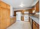 Well-lit kitchen featuring wood cabinets, white appliances, and modern tile flooring at 800 Park View Pl, Castle Rock, CO 80104