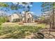 Large backyard with mature trees, including a brick chimney, patio, and well-kept lawn at 12258 E Lasalle Pl, Aurora, CO 80014