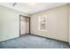 Simple bedroom with an open closet, window, and aged blue carpeting at 12258 E Lasalle Pl, Aurora, CO 80014