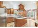 Well-equipped kitchen with wood cabinets, a kitchen island with a cooktop, and stainless steel appliances at 12258 E Lasalle Pl, Aurora, CO 80014