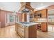 Charming kitchen features a central island with a cooktop and wooden cabinets at 12258 E Lasalle Pl, Aurora, CO 80014