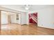 Bright living room with hardwood floors, an open layout, and a view of the foyer and staircase at 12258 E Lasalle Pl, Aurora, CO 80014