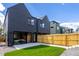 Contemporary home boasts a fenced backyard with a concrete patio and vibrant green lawn at 2478 S Cherokee St, Denver, CO 80223