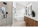 Contemporary bathroom features a glass shower, soaking tub, and wooden double vanity at 2478 S Cherokee St, Denver, CO 80223