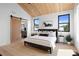 Stylish bedroom with vaulted wood ceiling, abundant light, and a rustic sliding barn door to ensuite at 2478 S Cherokee St, Denver, CO 80223