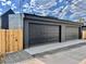 Two-car garage with dark doors and modern siding, complete with privacy fence at 2478 S Cherokee St, Denver, CO 80223