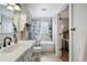 Bright bathroom with tiled walls, white vanity, and a bathtub-shower combination with floral curtain at 796 Ivanhoe St, Denver, CO 80220