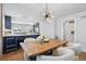Open dining space with an elegant light fixture, hardwood floors, and a view into the kitchen at 796 Ivanhoe St, Denver, CO 80220