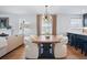 Bright dining area featuring hardwood floors, a modern light fixture, and seamless flow into the kitchen at 796 Ivanhoe St, Denver, CO 80220