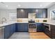 Stylish kitchen featuring gray cabinets, stainless steel appliances, white countertops, herringbone backsplash, and wood floors at 796 Ivanhoe St, Denver, CO 80220