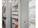 Convenient laundry area with stacked washer and dryer, built-in shelves, and adjacent bathroom at 796 Ivanhoe St, Denver, CO 80220