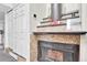 Close-up of a wood burning fireplace with granite surround and adjacent coat closet at 8701 Huron St # 211, Thornton, CO 80260
