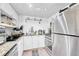 Well-lit kitchen featuring white cabinetry and stainless steel refrigerator and oven at 8701 Huron St # 211, Thornton, CO 80260