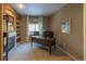 Home office features built-in shelves, fireplace, and large window offering natural light at 4236 Lark Sparrow St, Highlands Ranch, CO 80126