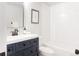 This bathroom features a vanity with a navy cabinet, matte black hardware and a white countertop, and tiled shower over tub at 1020 Stuart, Denver, CO 80204